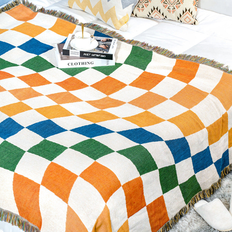 Couverture douce avec motif à damier coloré et pompons