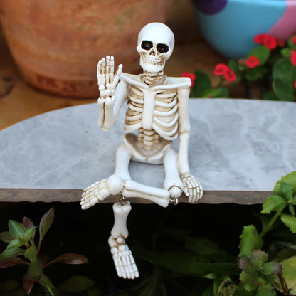 Décoration d'Halloween en résine représentant un squelette avec une main qui fait signe