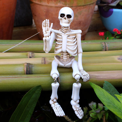 Décoration d'Halloween en résine représentant un squelette avec une main qui fait signe