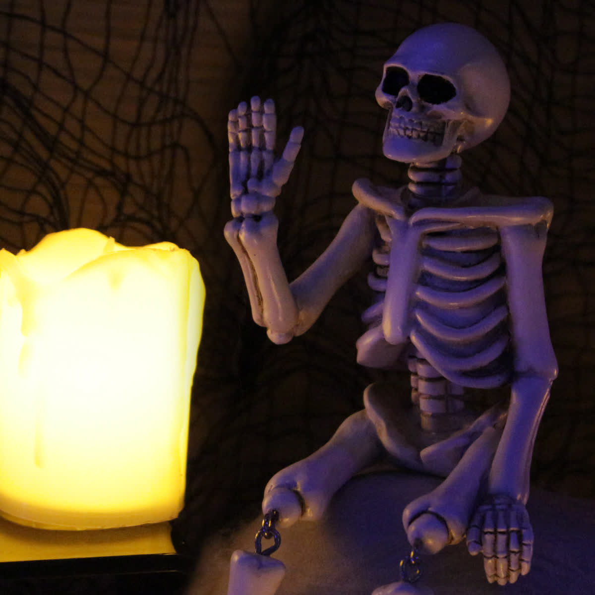 Décoration d'Halloween en résine représentant un squelette avec une main qui fait signe