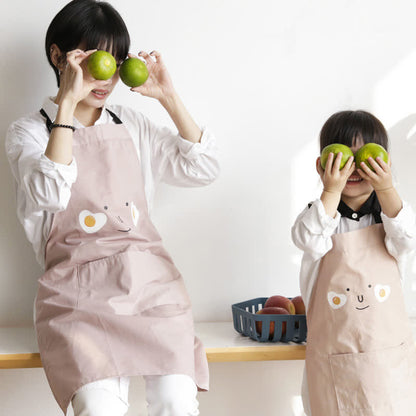 Sourire d'œuf au plat, tablier imperméable parent-enfant