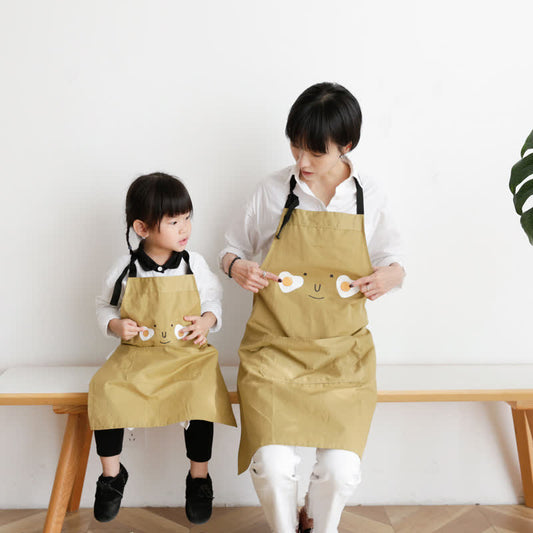 Sourire d'œuf au plat, tablier imperméable parent-enfant