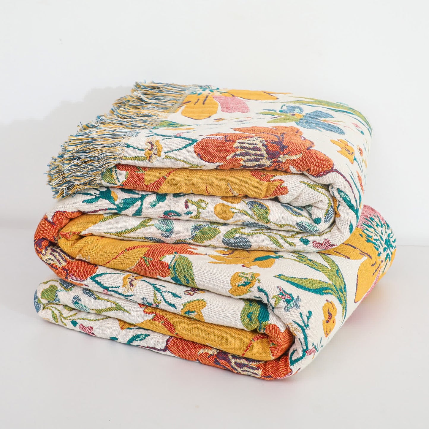 Couverture réversible en gaze de coton avec pompons et motif floral lumineux