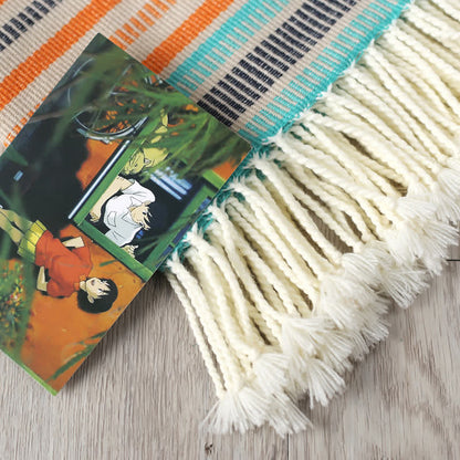 Couverture arc-en-ciel douce, colorée et rayée avec des pompons